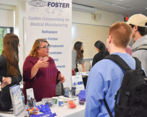 A representative from Foster talks with students about the manufacturing employment opportunities at the company.