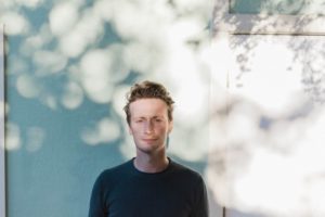 Edgar Kunz standing in front of blue wall